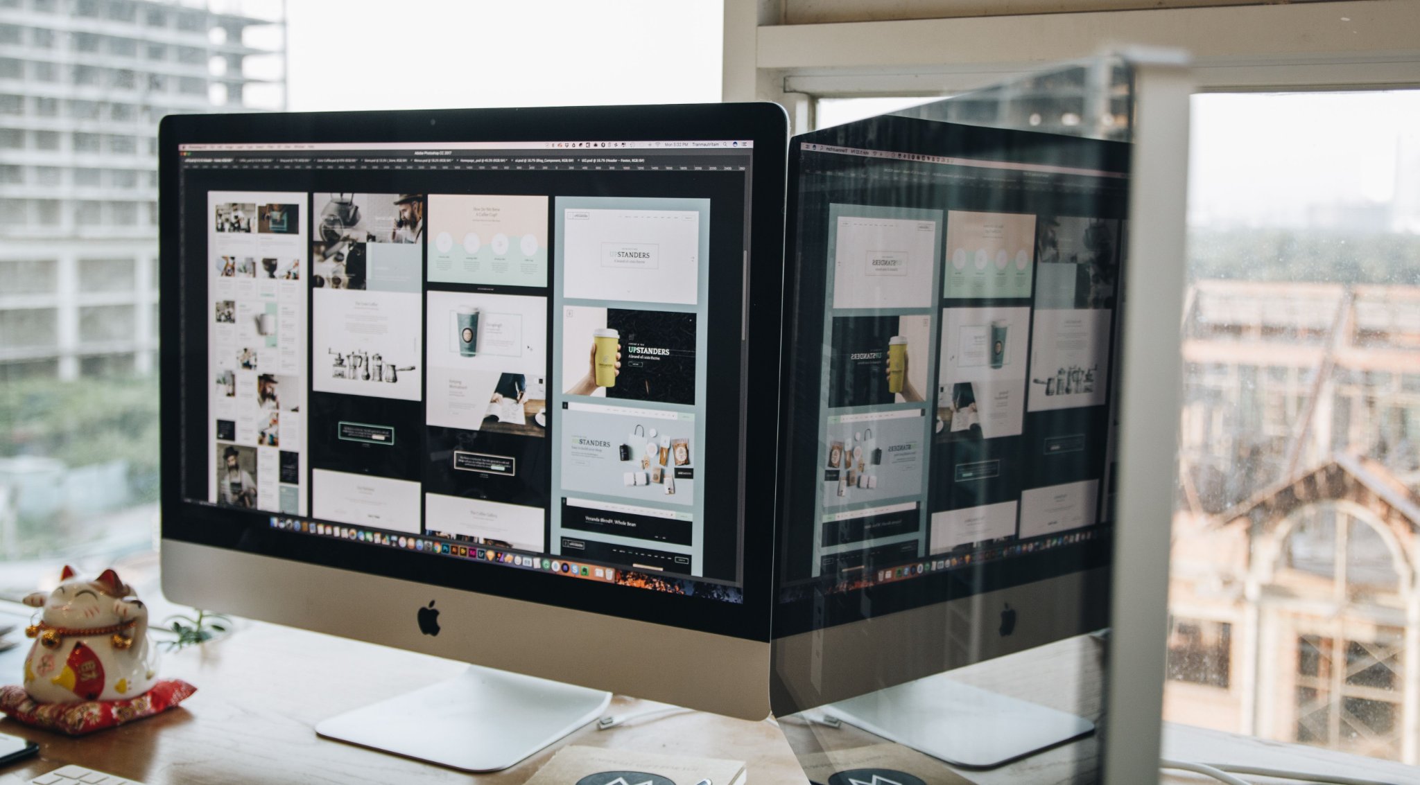 Photo of an iMac on a desk showing website design mockups